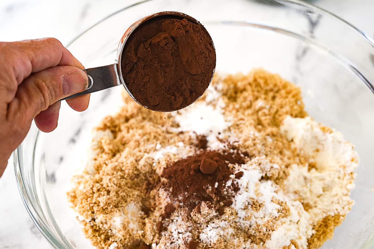 adding baking cocoa to a bowl