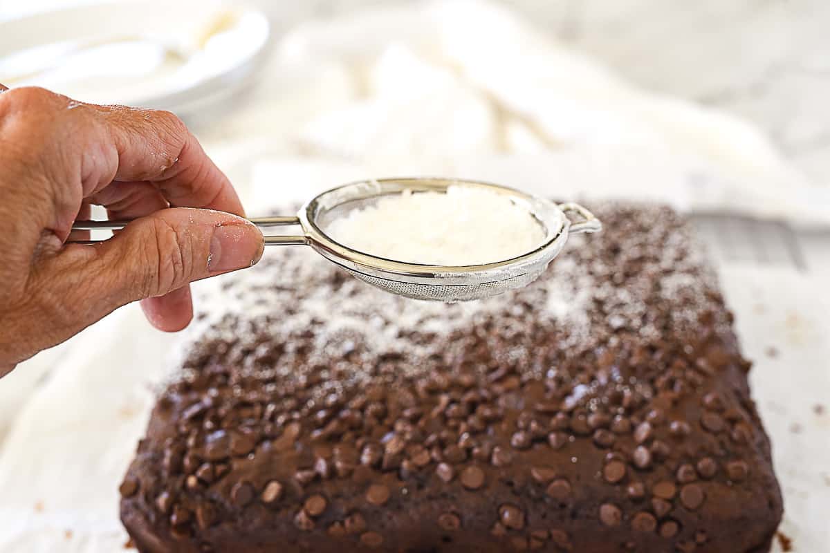 sprinkling chocolate cake with powdered sugar