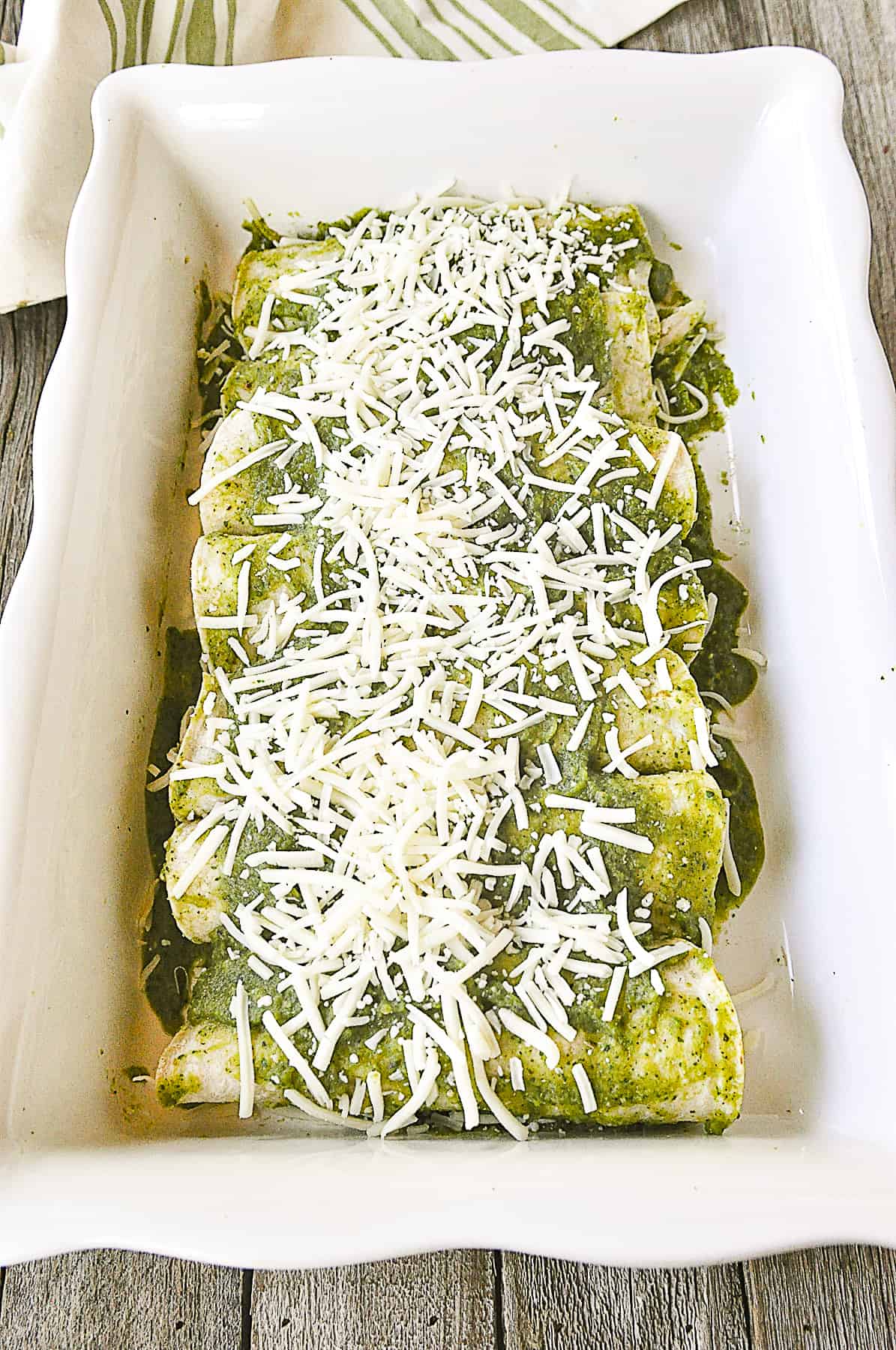 green chili enchiladas rolled up and ready for the oven.