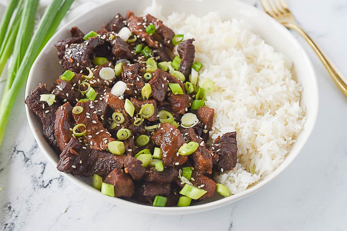 Korean bbq Beef and rice in a bowl with green onions on top