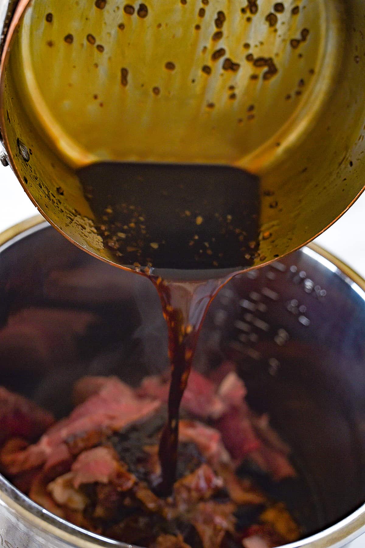 pouring sauce over beef in instant pot