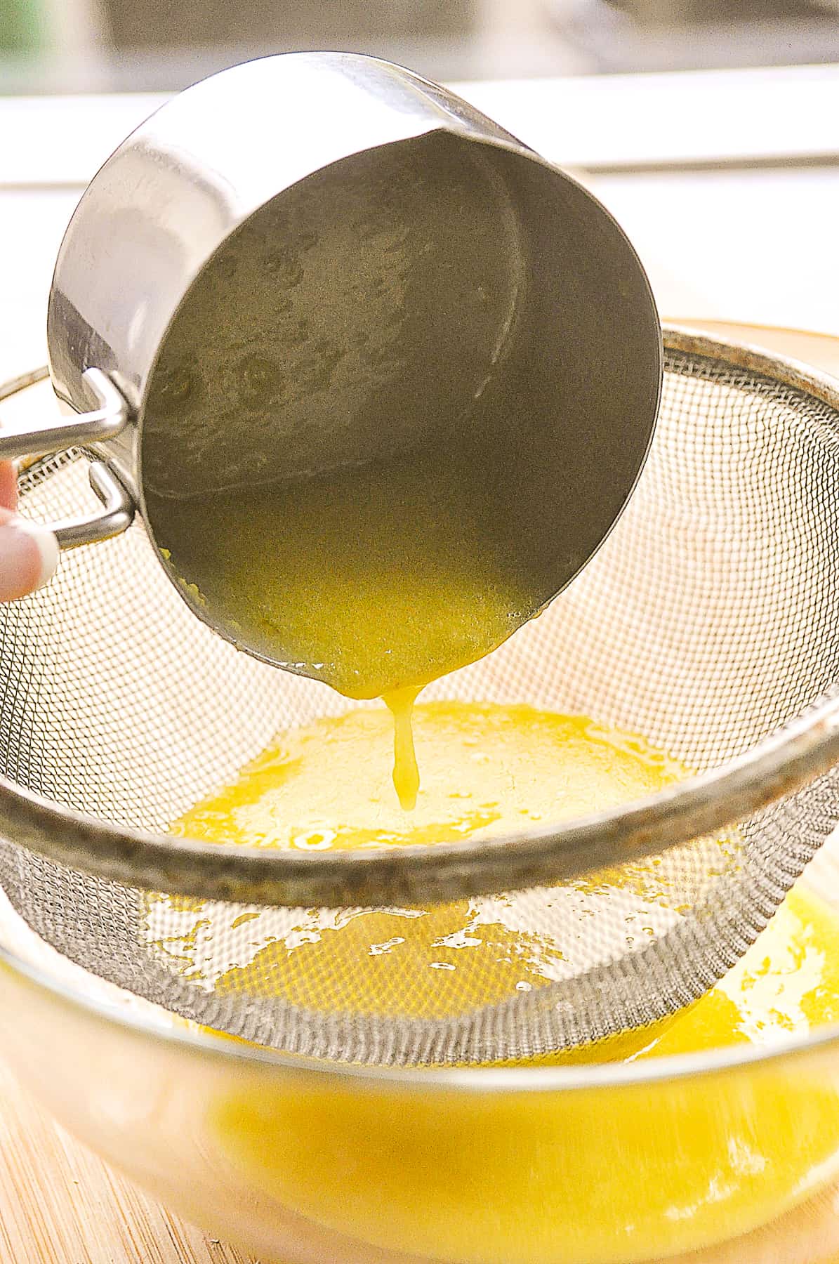 pouring lemon curd through strainer