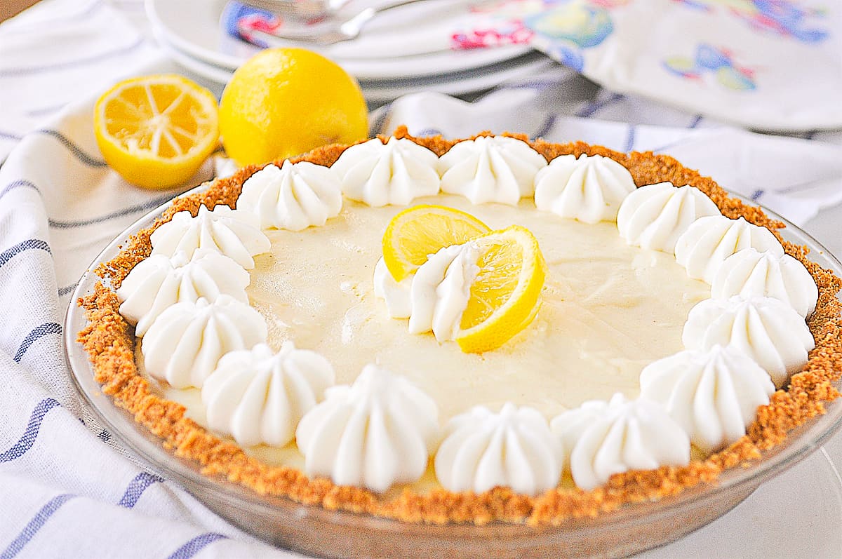 lemon chiffon pie with graham cracker crust and slice of lemon on top