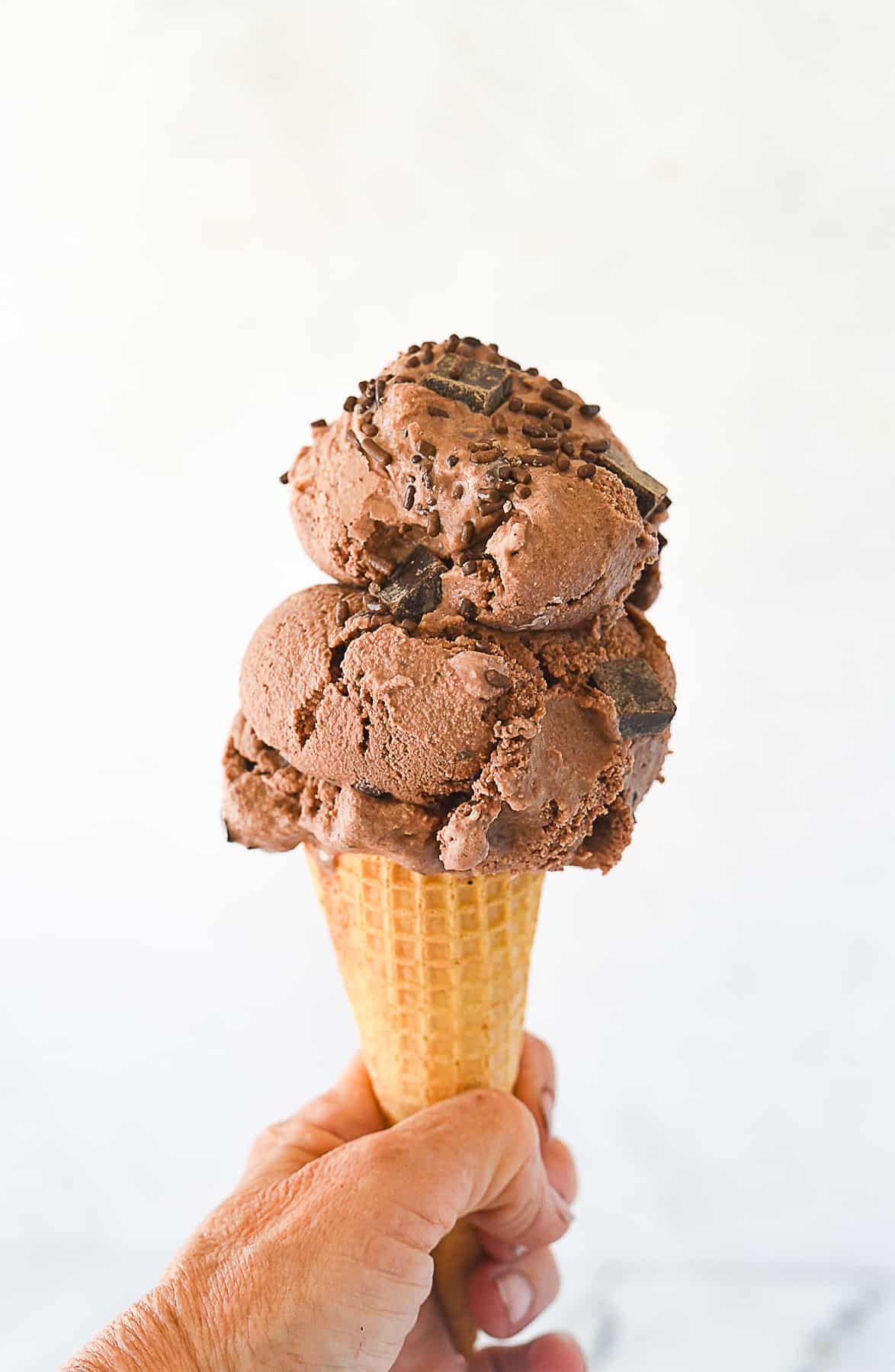 hand holding a chocolate ice cream cone