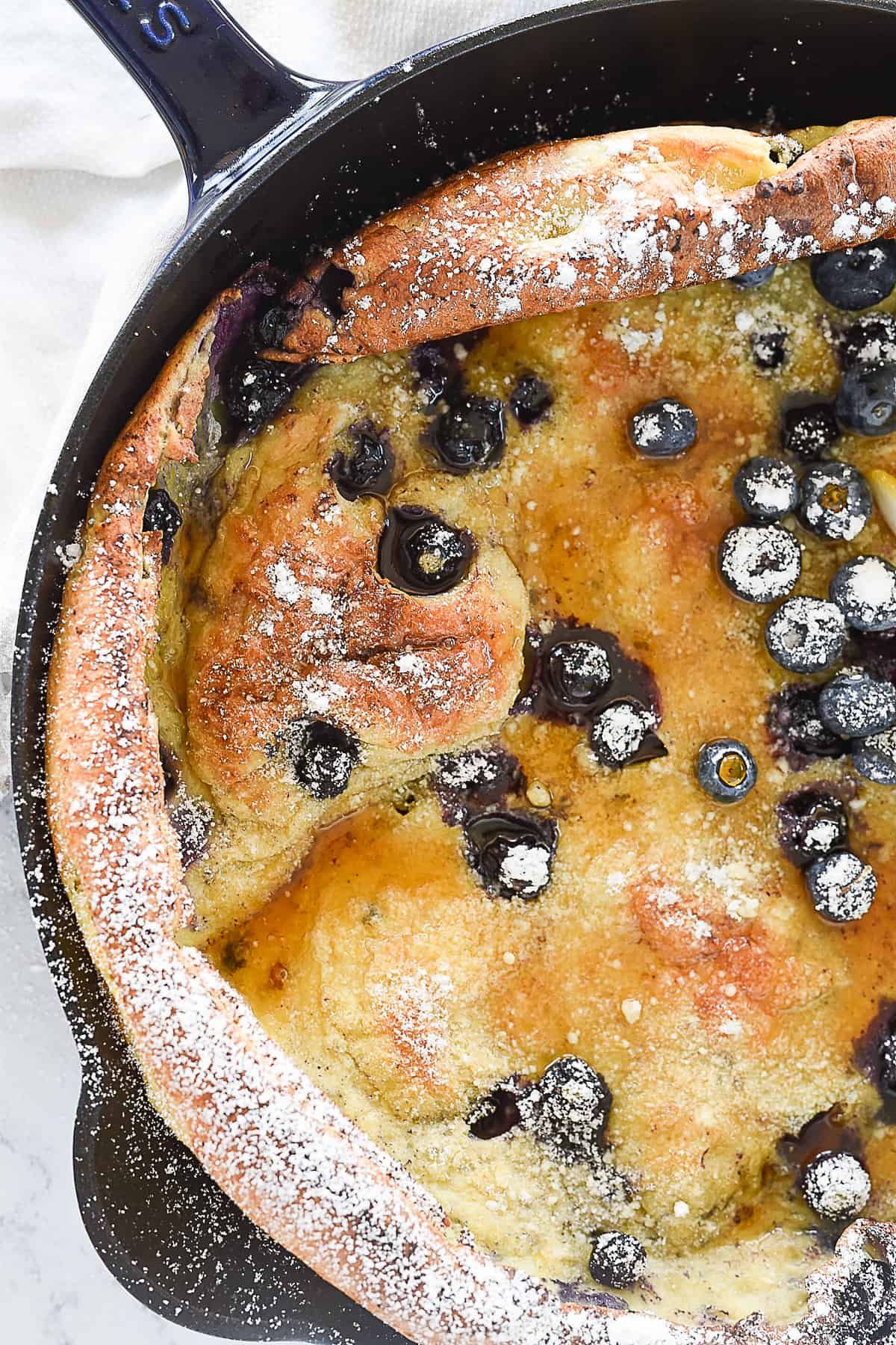 lemon blueberry dutch baby in a cast iron pan