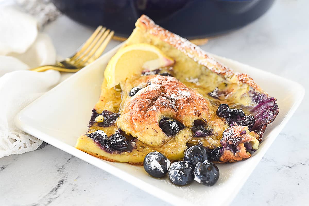 slice of lemon blueberry dutch baby on a plate.