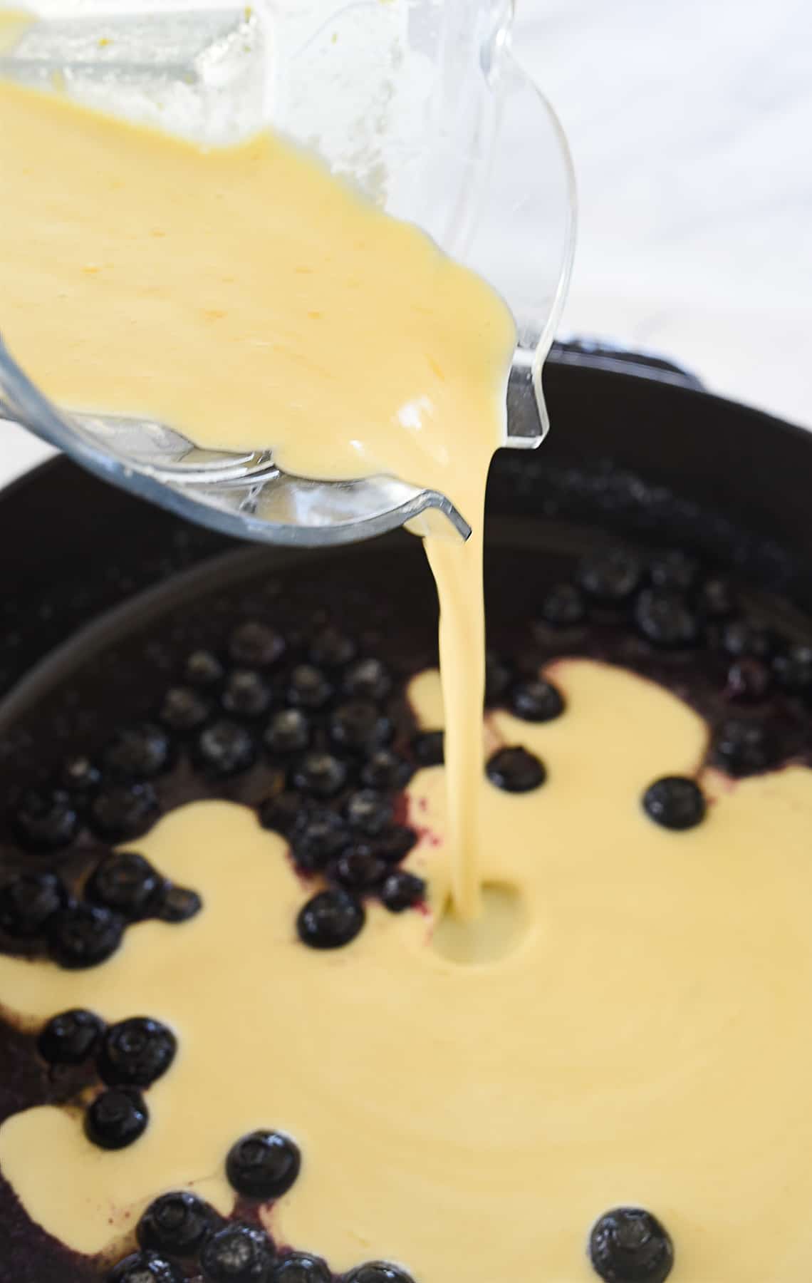 pouring batter into cast iron pan