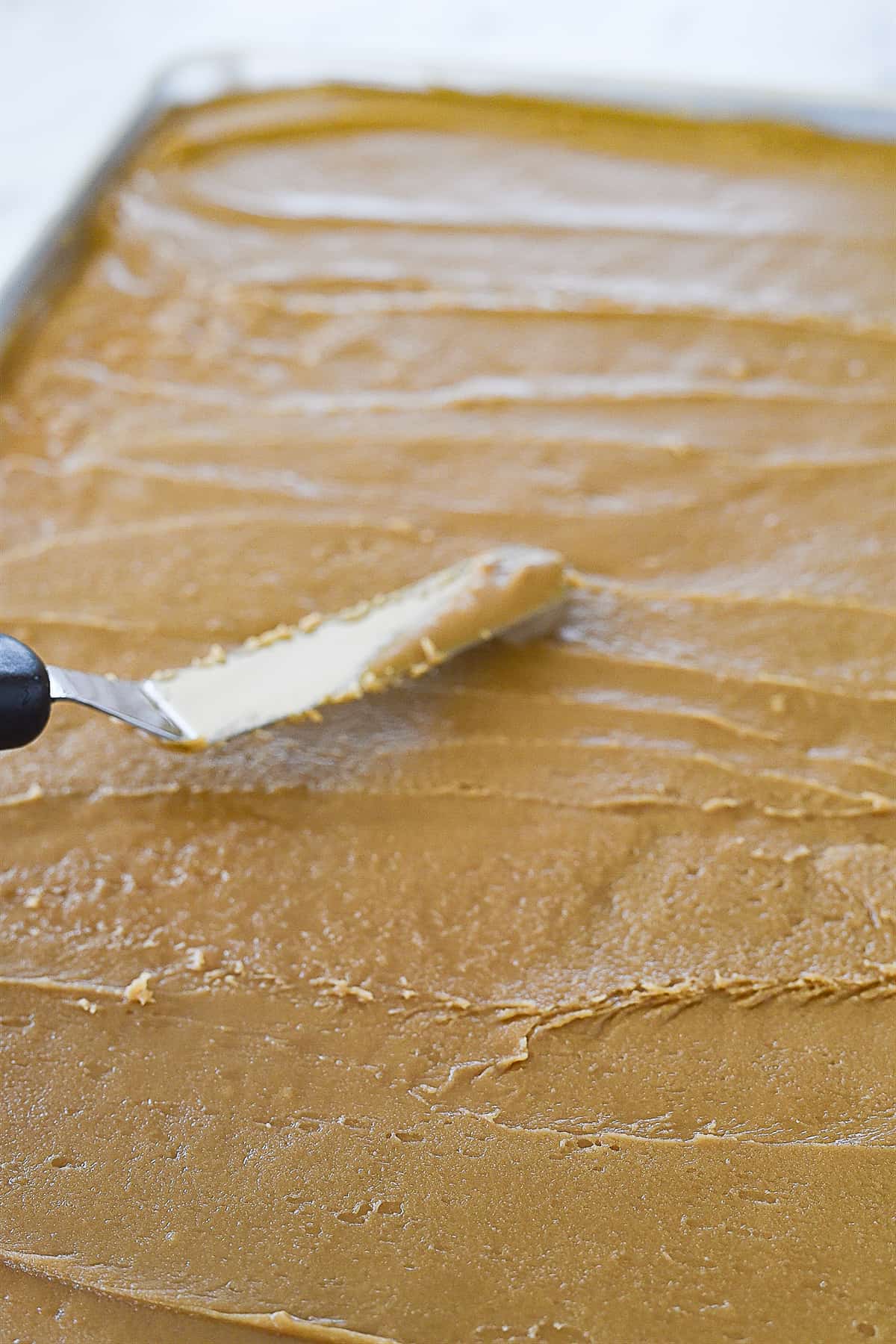 spreading frosting on cake