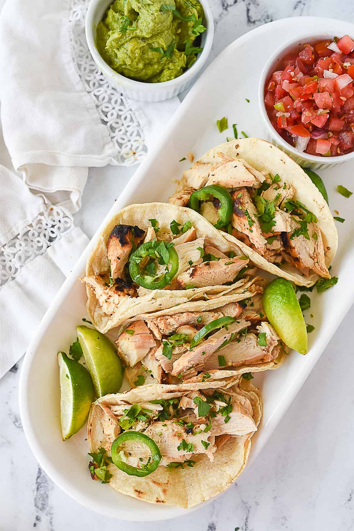 overhead shot of chicken tacos on a white plate