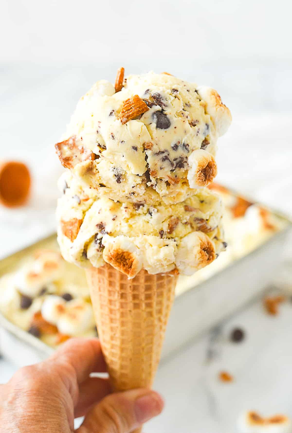 hand holding an ice cream cone of s'mores ice cream
