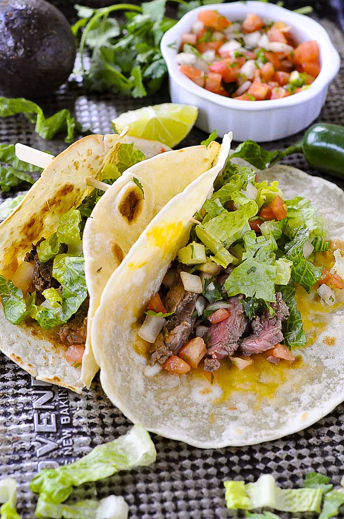 two steak tacos on a baking sheet