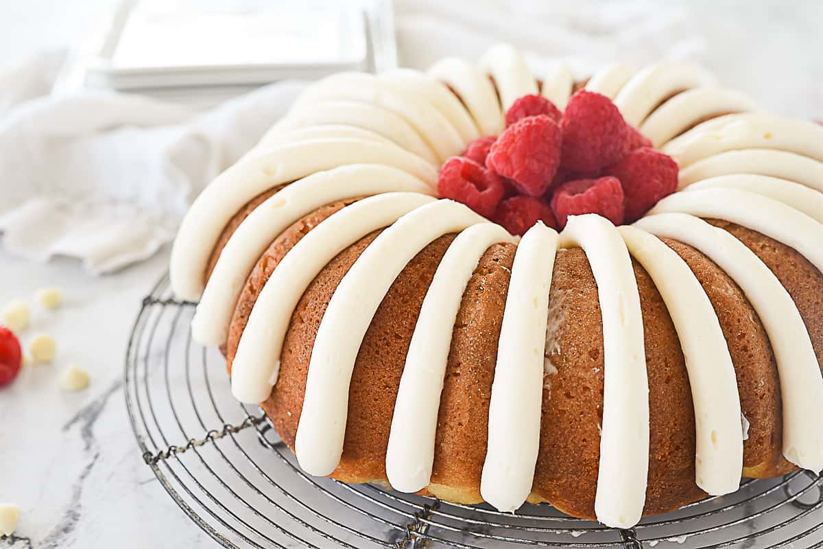 white chocolate raspberry bundt cake with raspberries in the middle