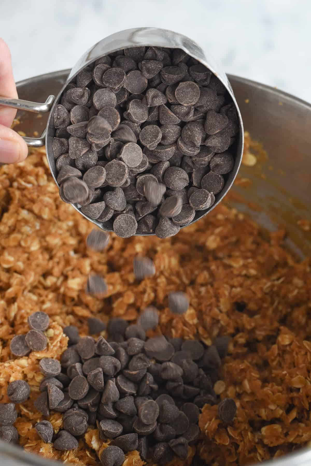 adding chocolate chips to monster cookie batter