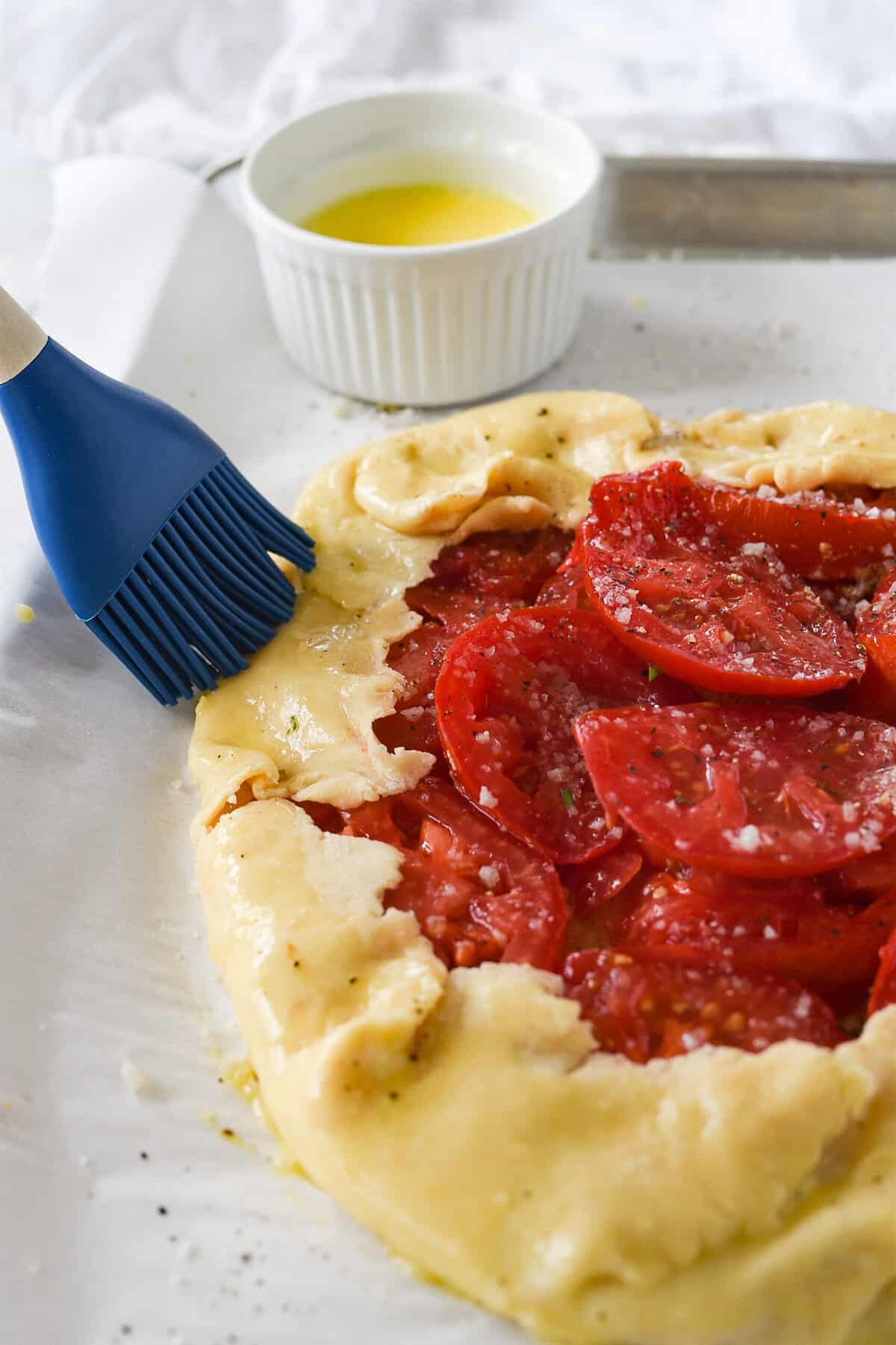 brushing galette dough with egg wash.