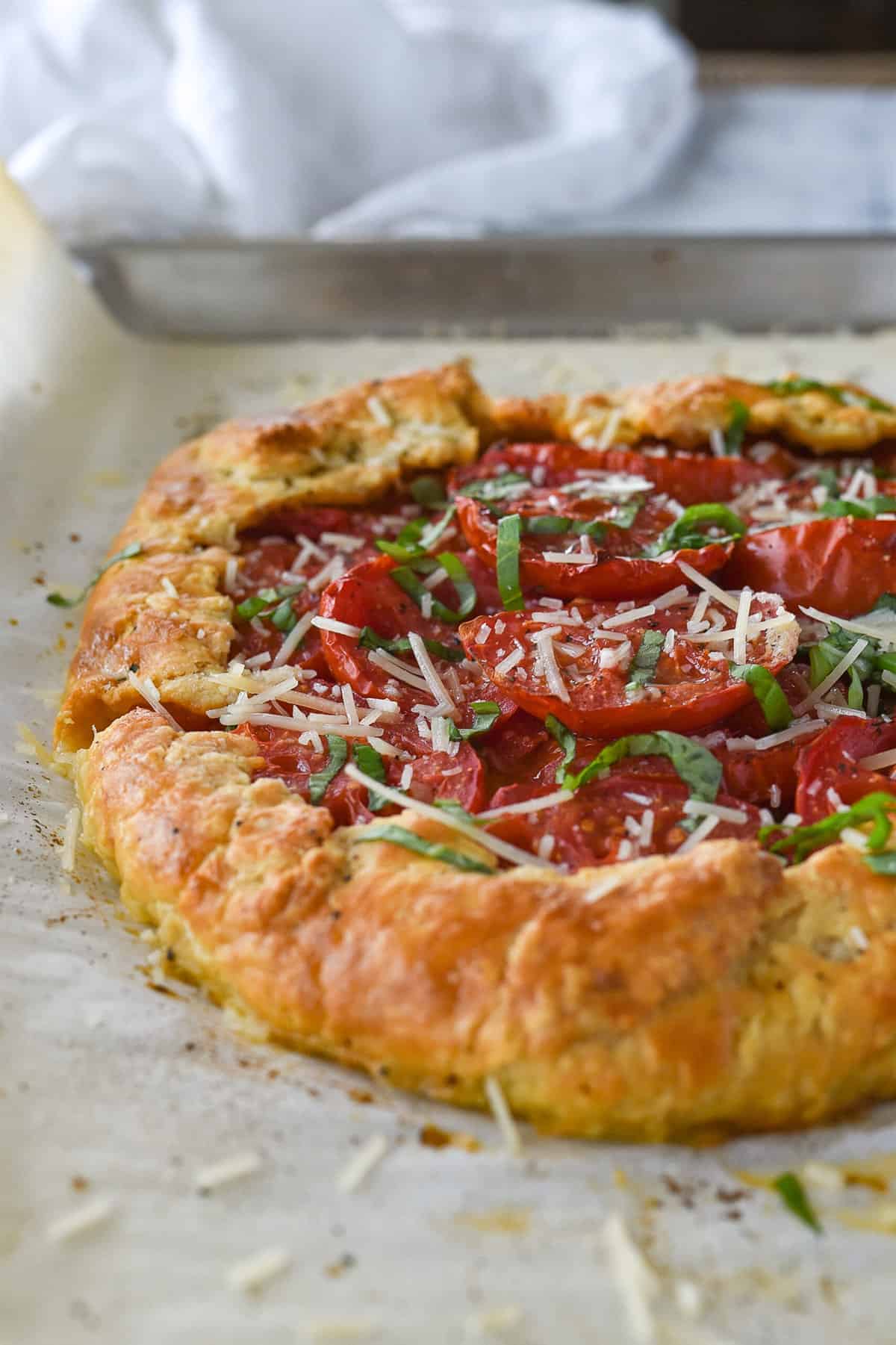 side view of a tomato galette on a baking sheet