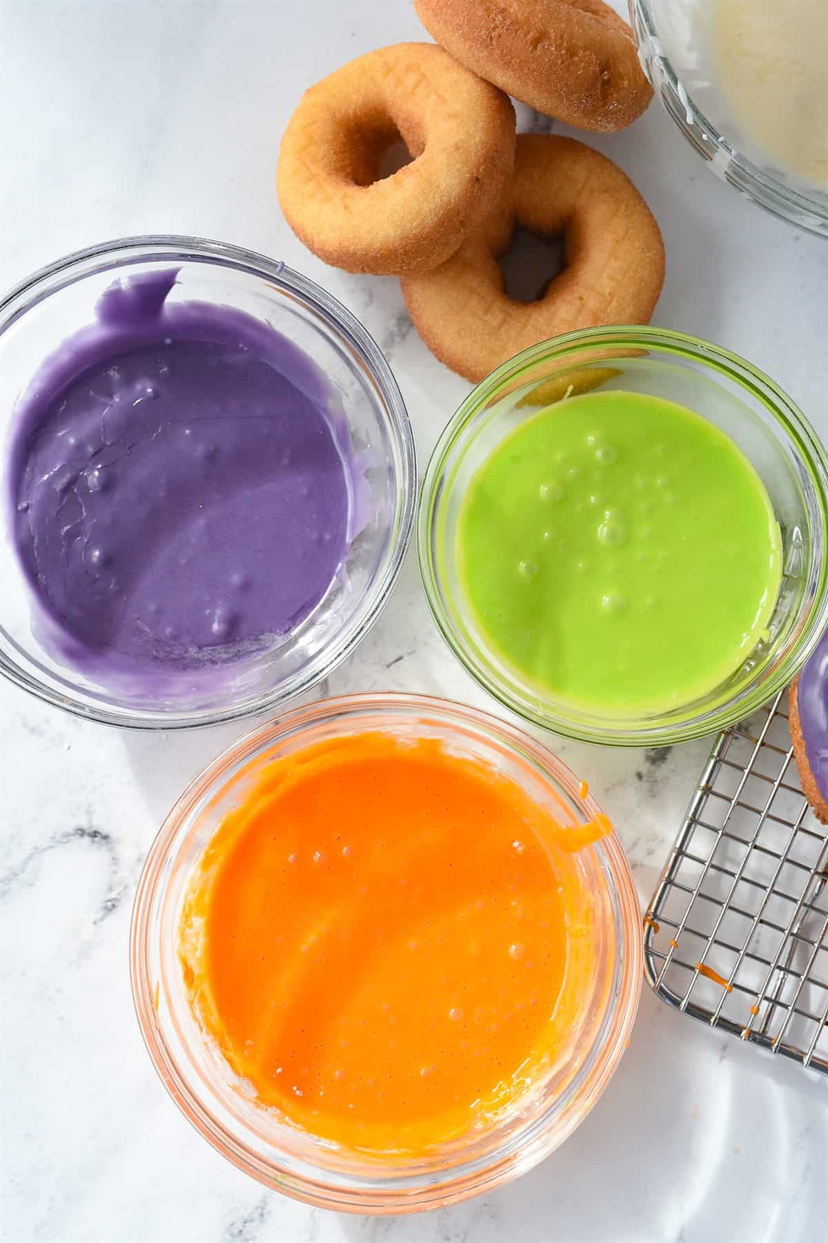bowls of colored glaze for halloween donuts