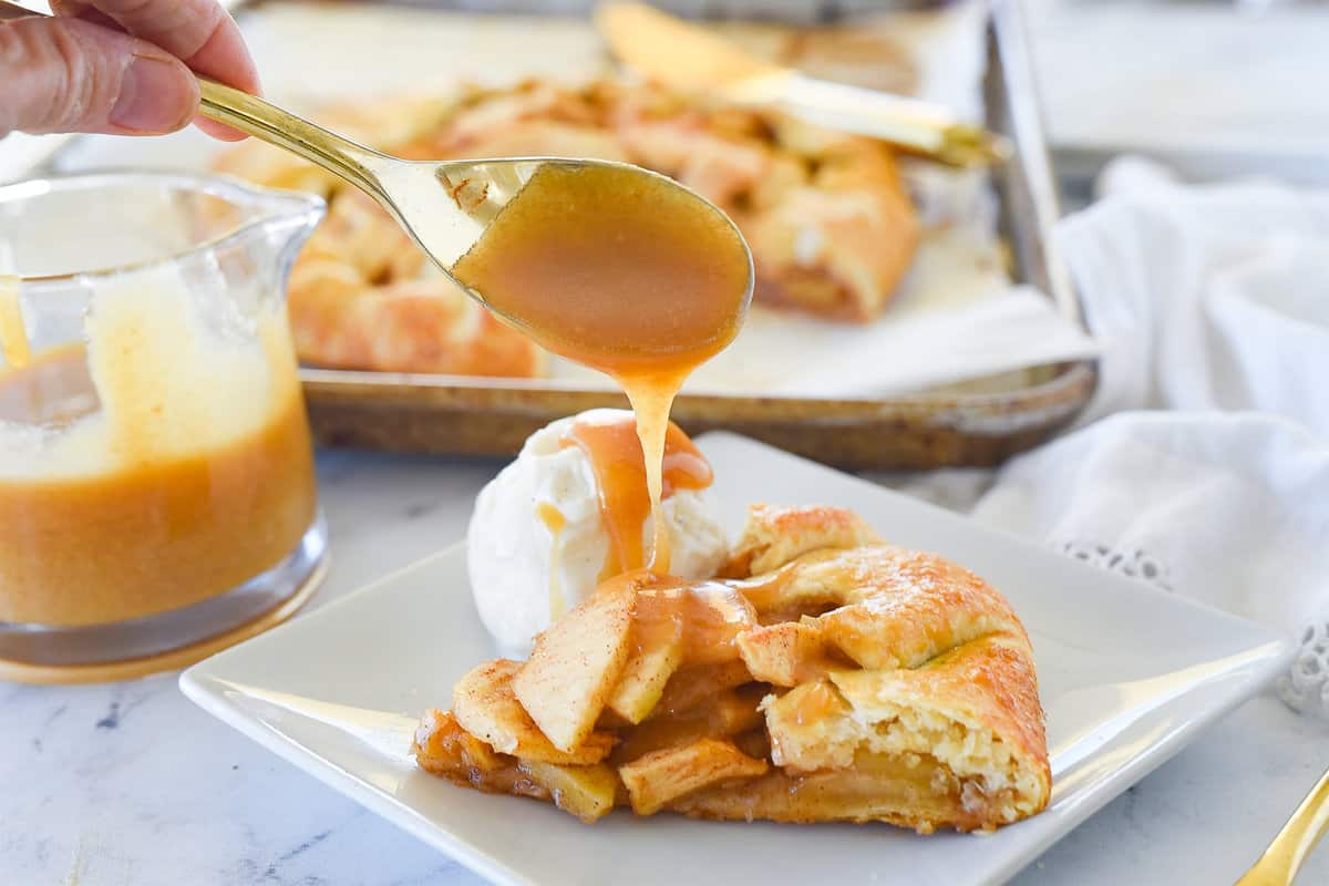 pouring caramel sauce over apple galette
