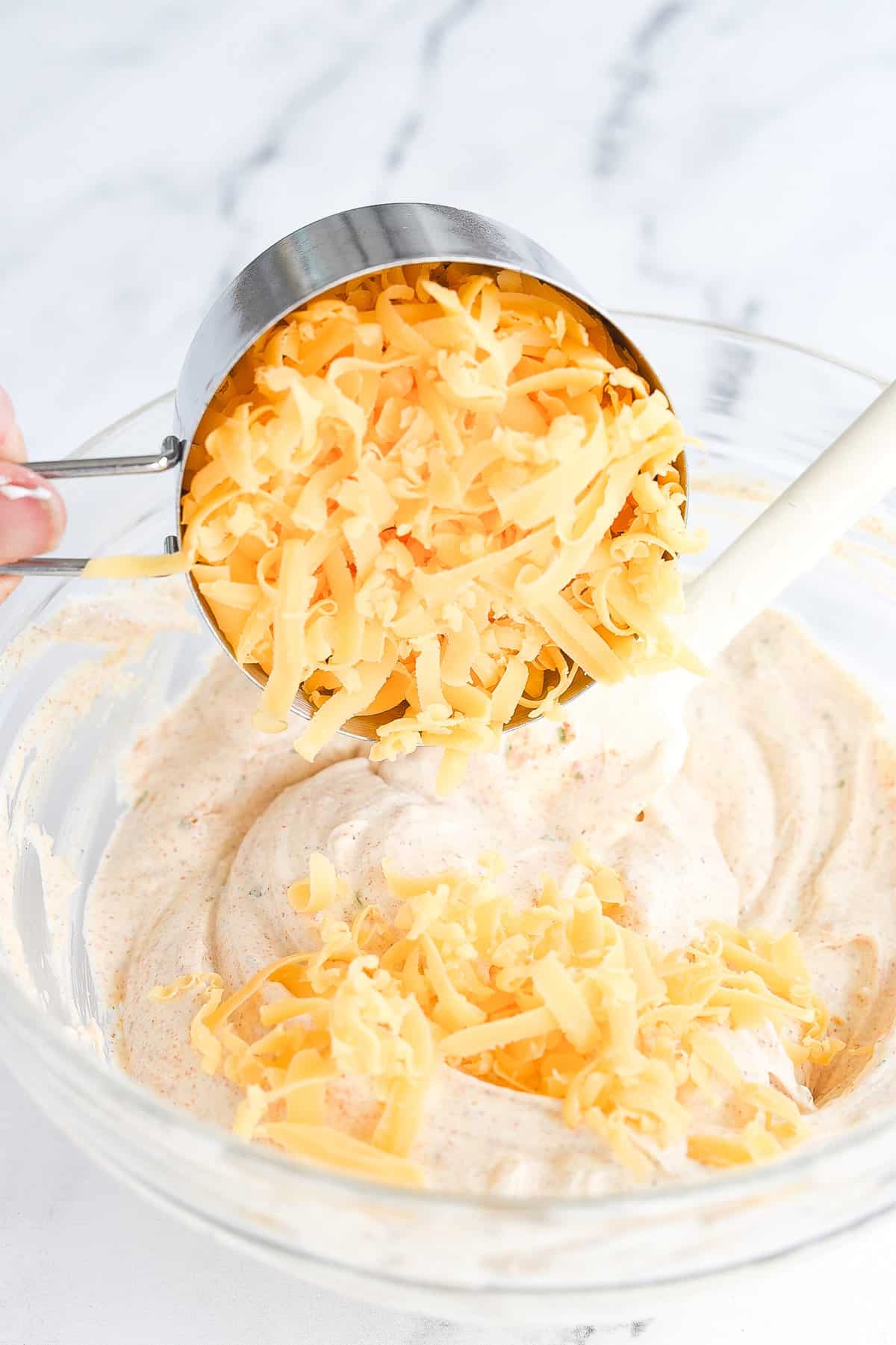 adding in grated cheese to fiesta ranch dip