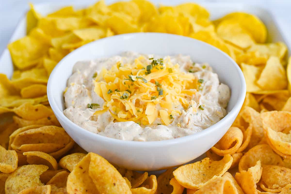 white bowl of dip with fritos around it