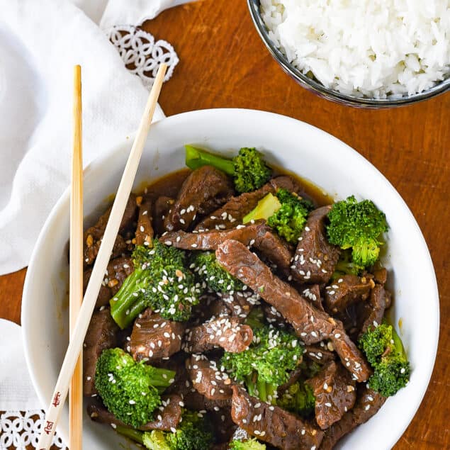 beef and broccoli in a white bowl with rice