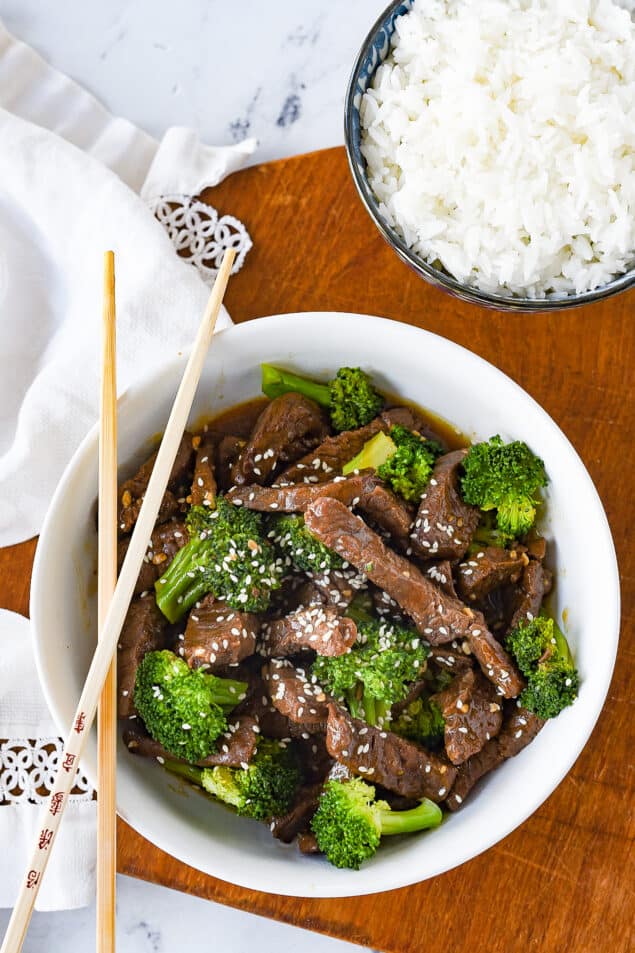 beef and broccoli in a white bowl with rice