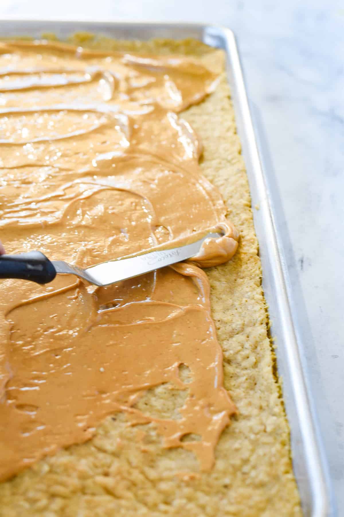 spreading peanut butter layer on cookie layer