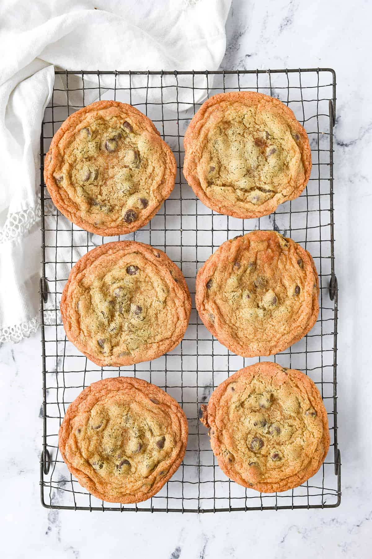 cooling rack with six large chocolate chip cookies on it