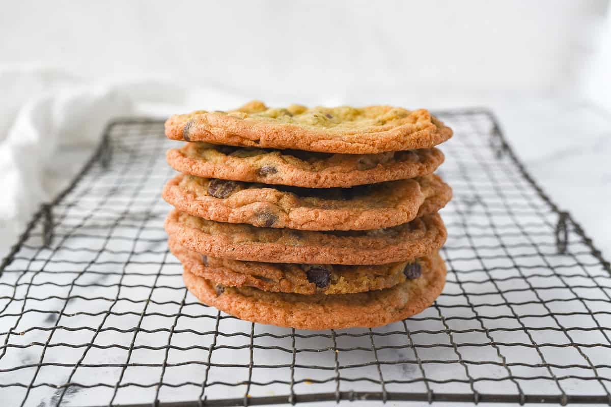 STACK OF FIVE CHOCOLATE CHIP COOKIES ON A COOLING RACK
