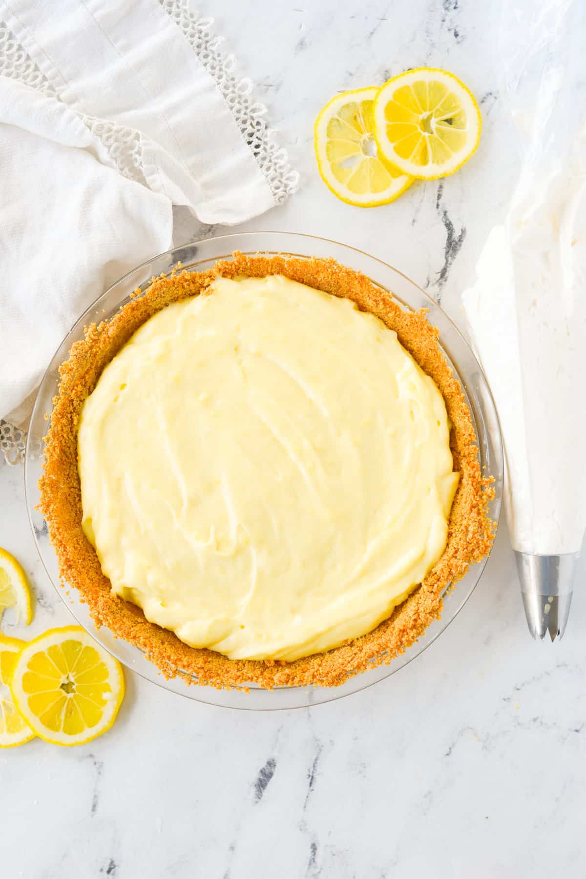 lemon pie with whipped cream in a pipping bag on the side