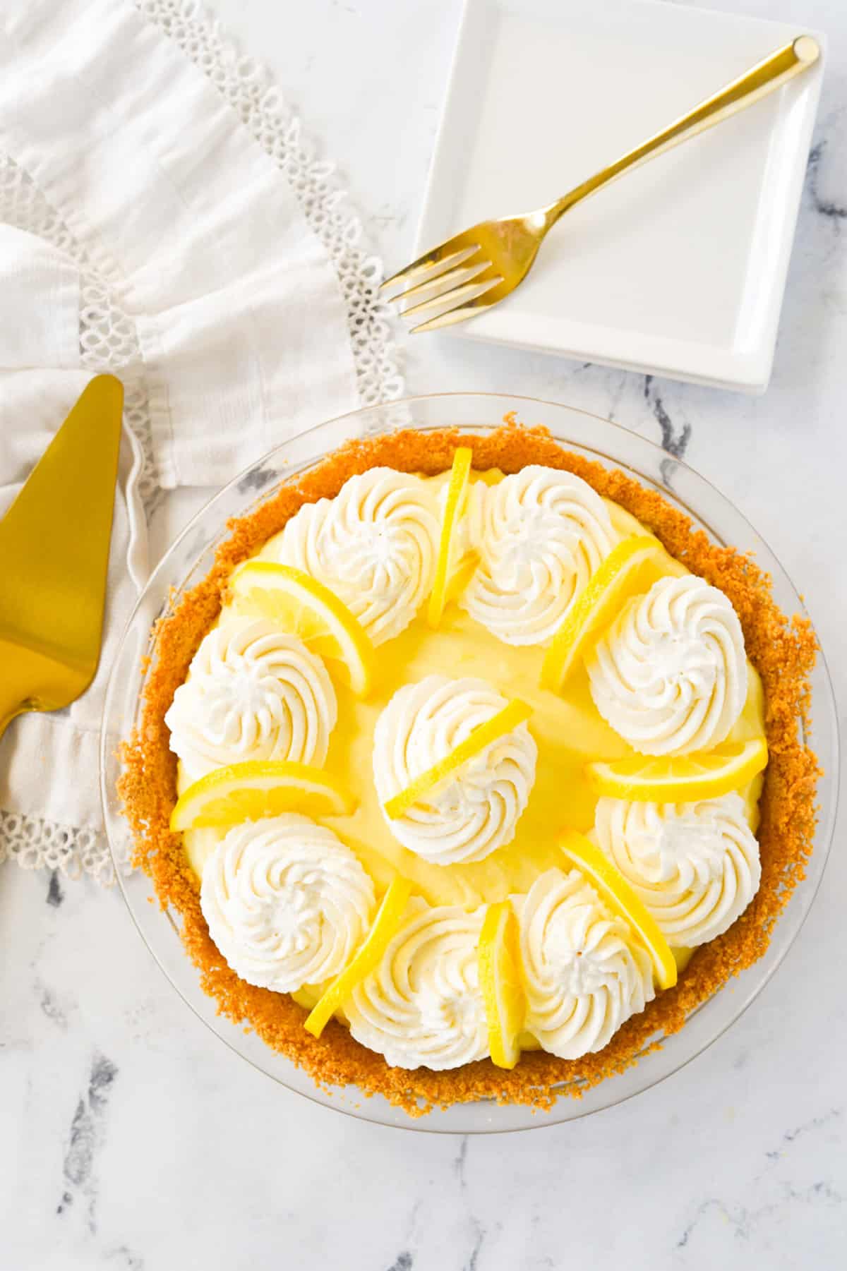 overhead shot of a sour cream lemon pie and a plate and fork