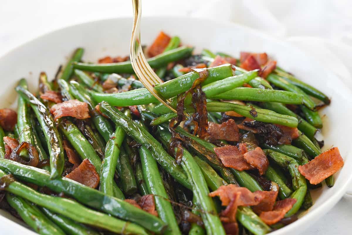 fork full of green beans with bacon