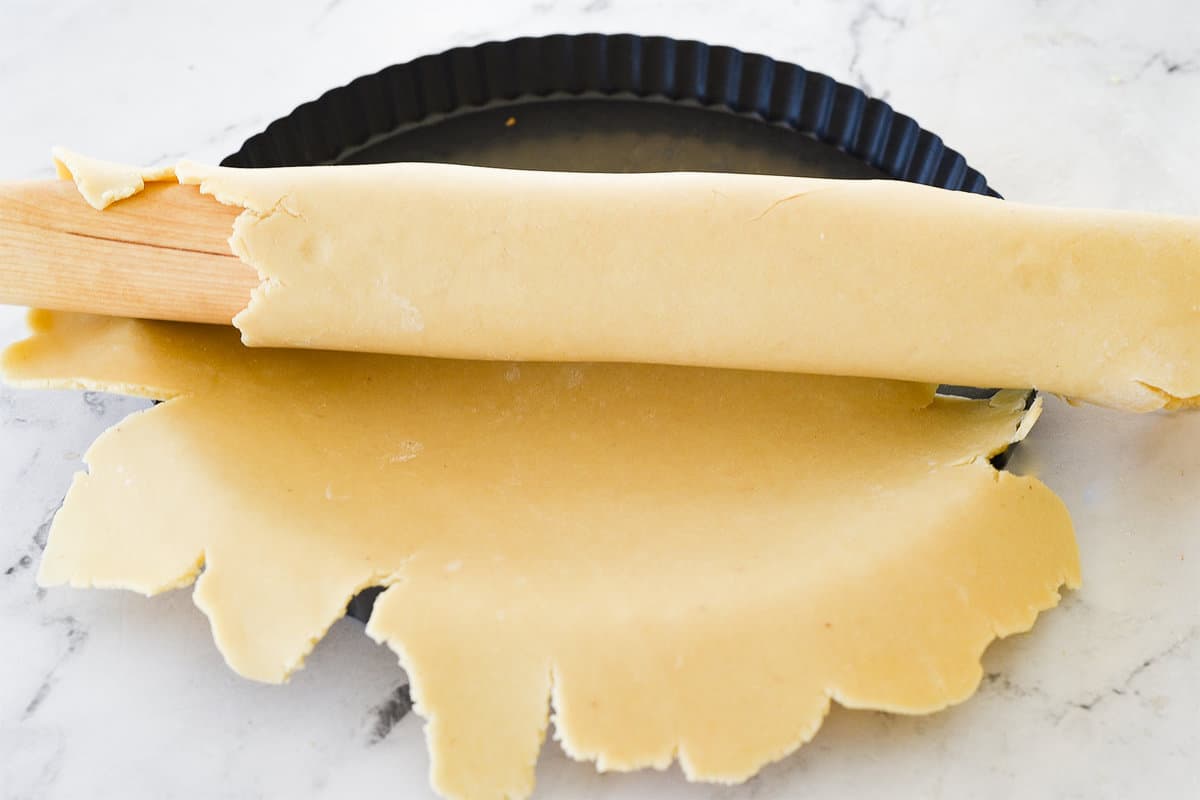 rolling dough out into tart pan