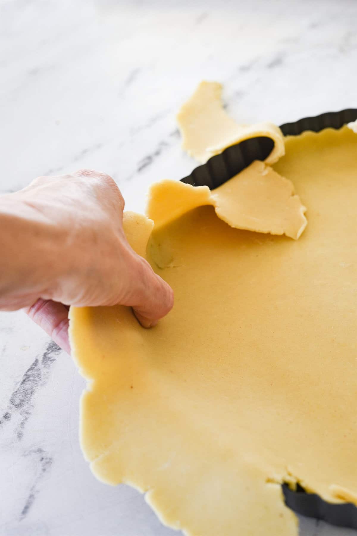 pushing dough into corners of tart pan.