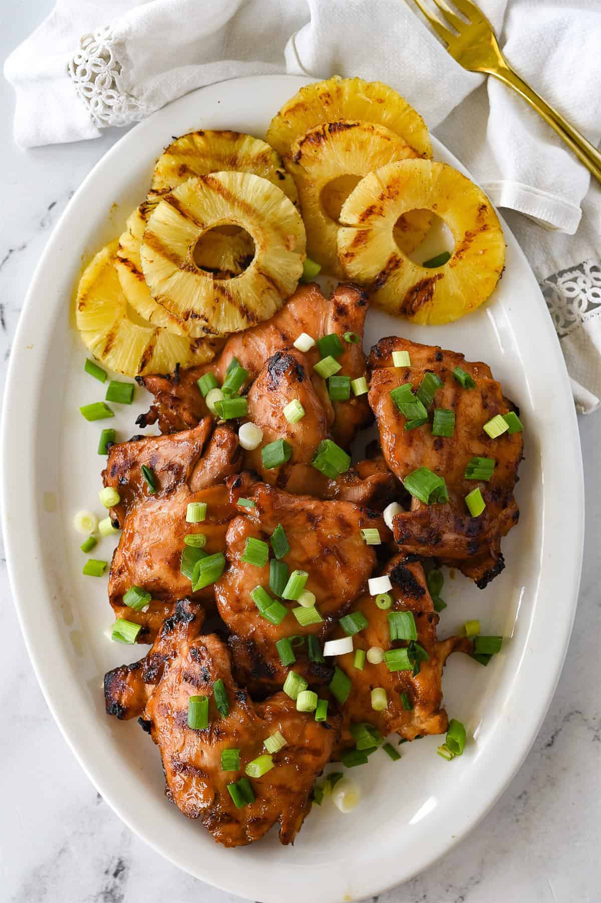 huli huli chicken and pineapple on a white platter