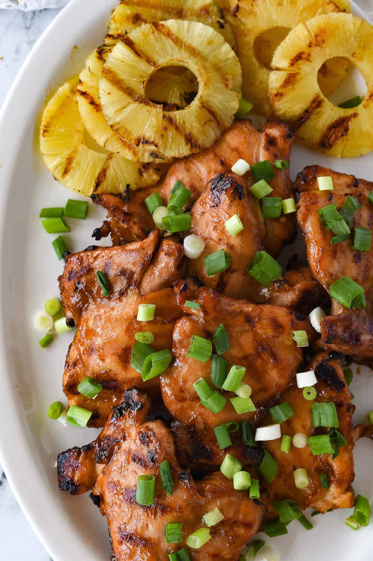 grilled huli huli chicken on a plate with pineapple