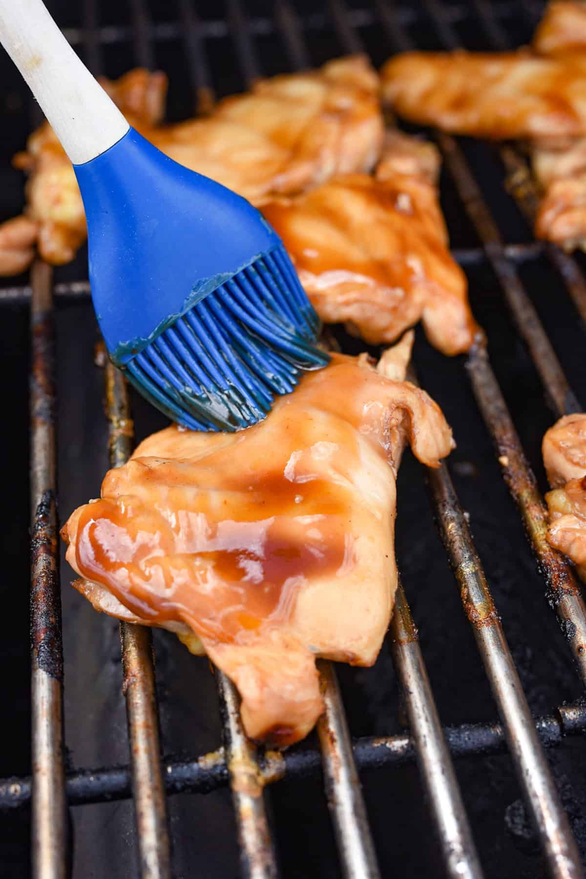 basting chicken on the grill with marinade