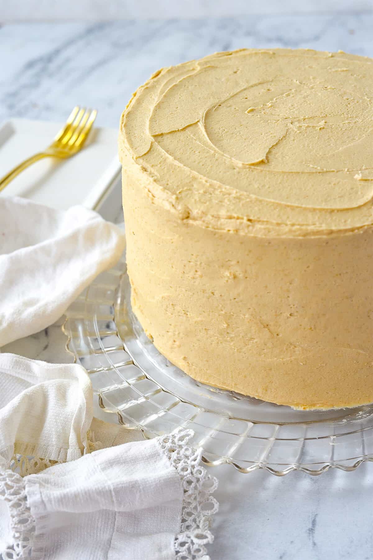 frosted caramel cake on cake plate