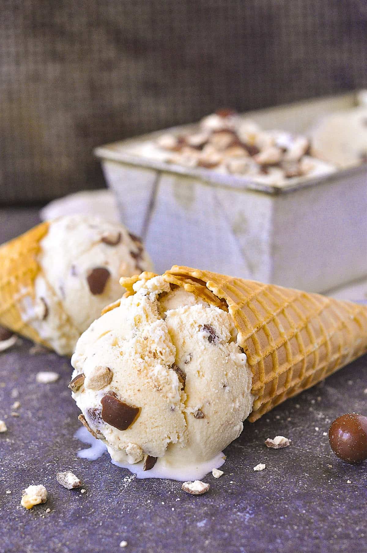 scoop of malted milk ice cream on a cone lying on it's side
