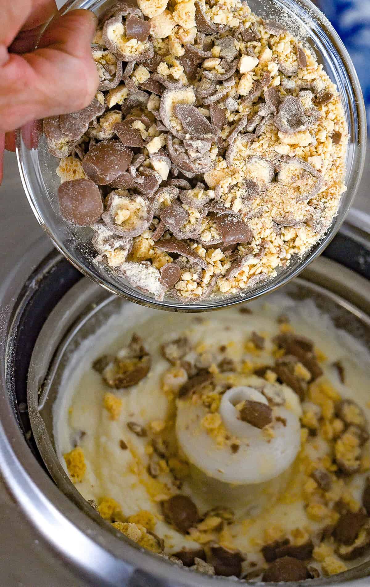 pouring crushed malted milk balls into the ice cream maker
