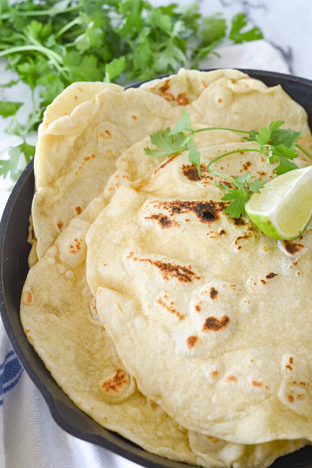 pile of flour tortillas in a cast iron pan