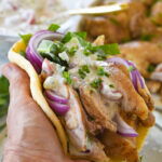 hand holding a chicken shawarma sandwich