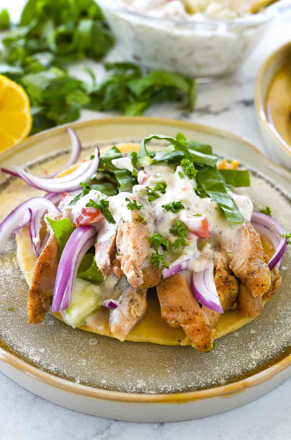 chicken shawarma on pita bread on a plate.