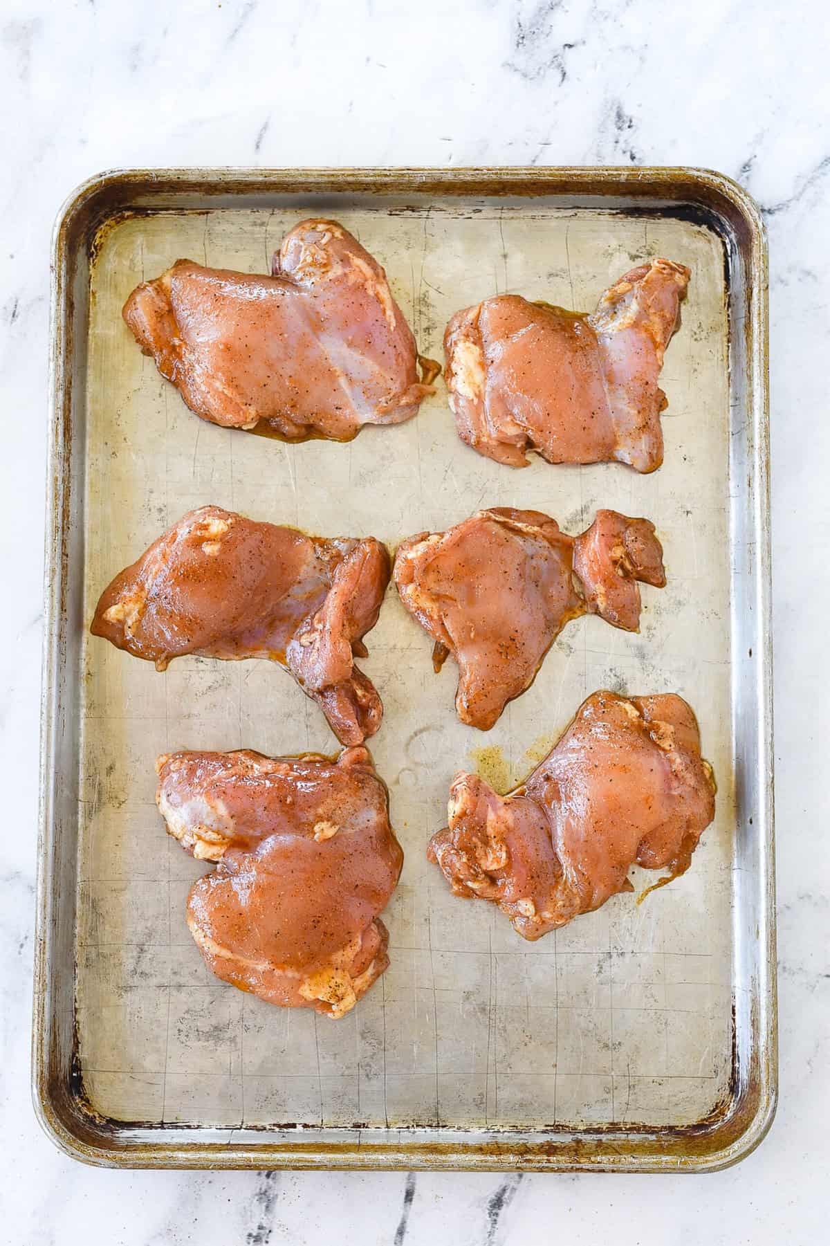 chicken thighs on a baking sheet
