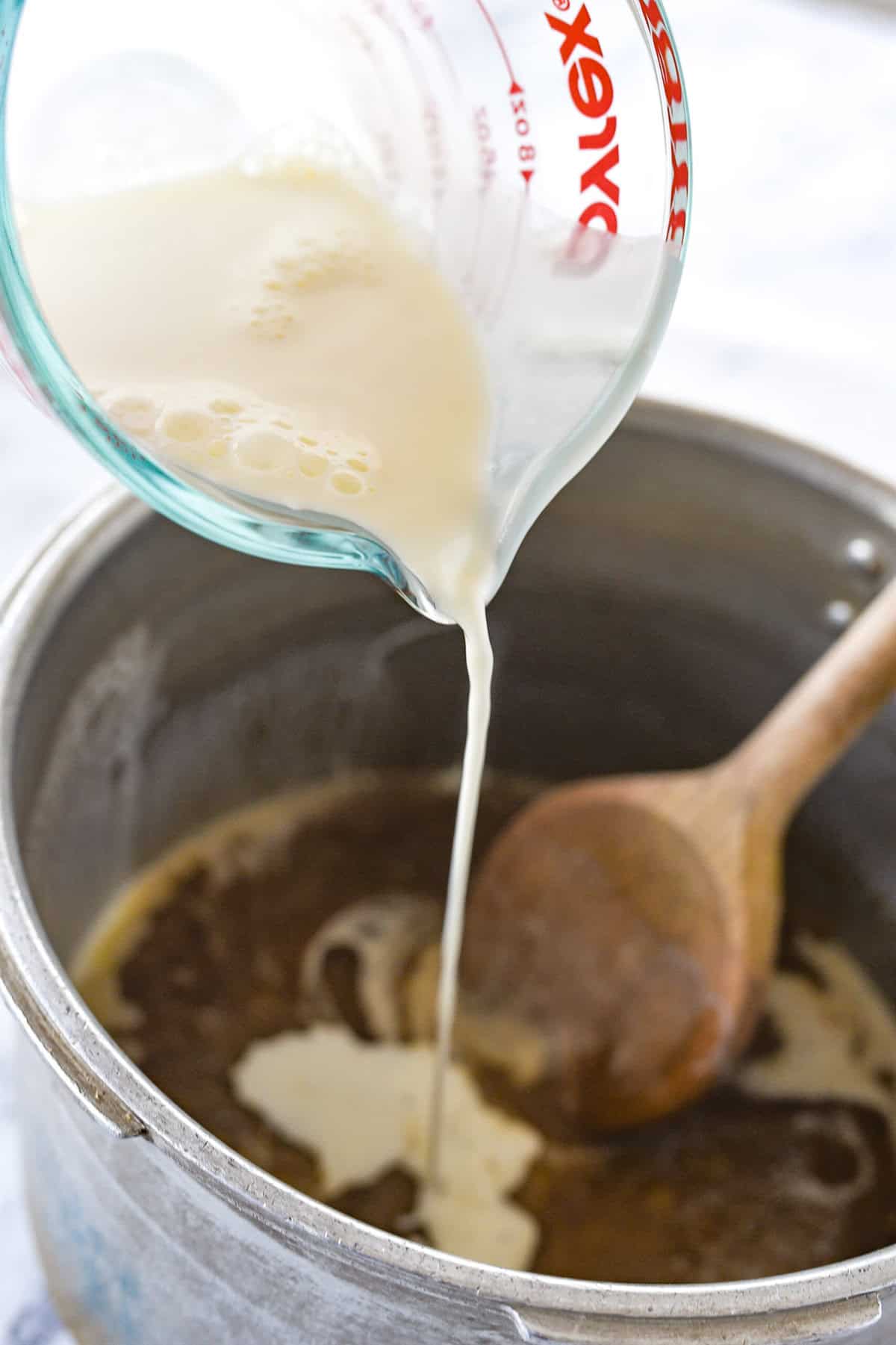adding cream to caramel sauce