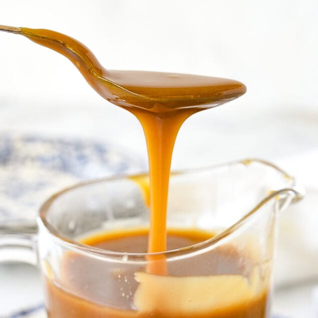 spoon drizzling caramel sauce into a bowl
