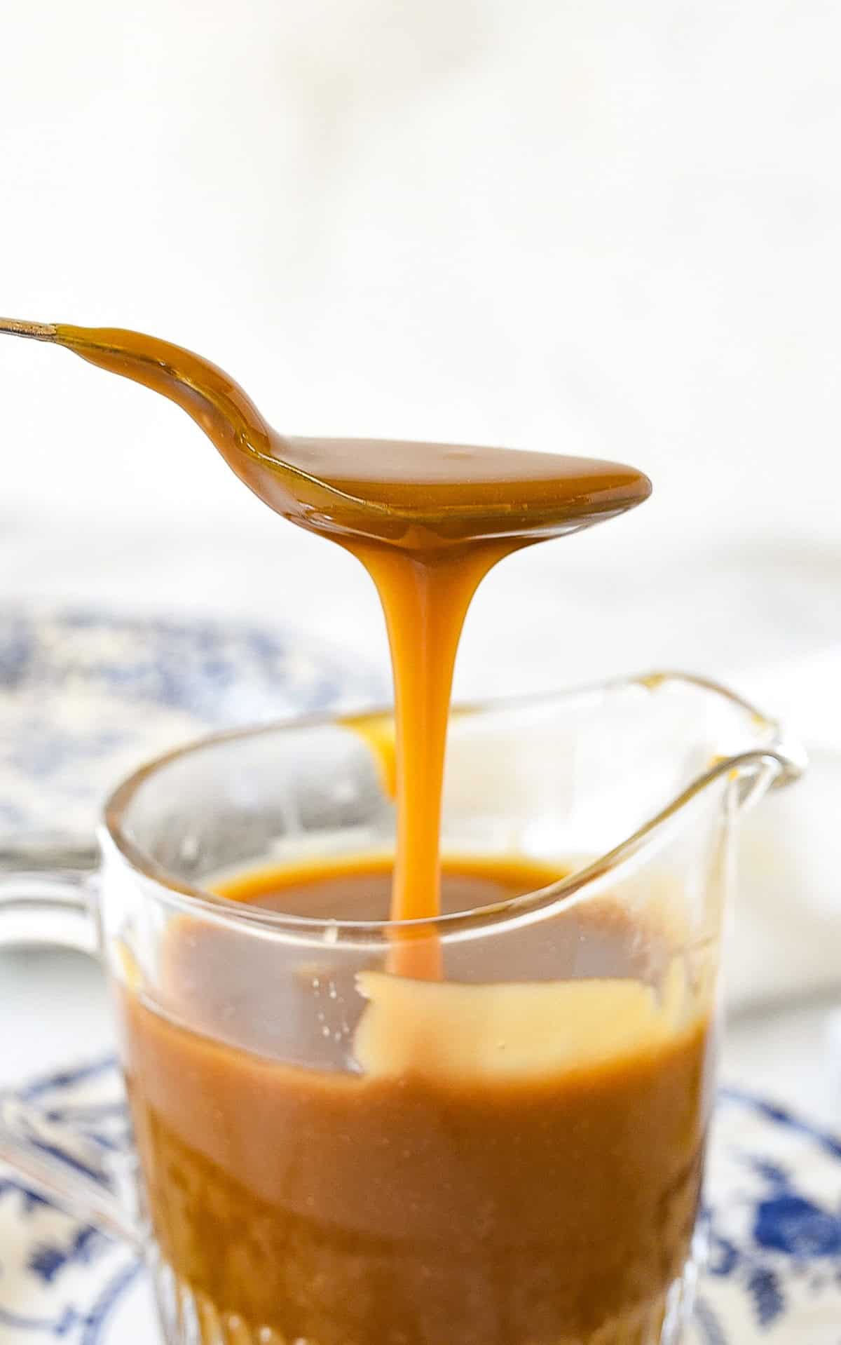 spoon drizzling caramel sauce into a bowl