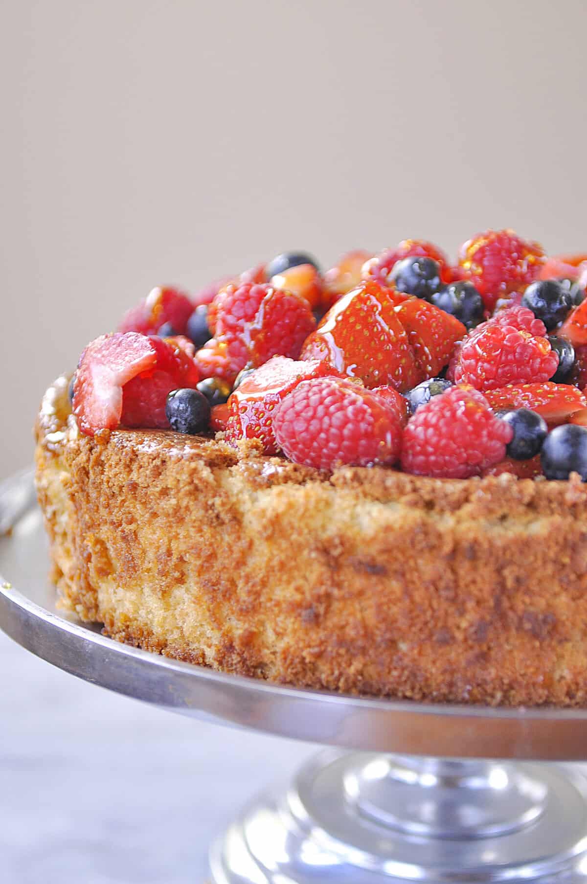 side view of almond cake with berries on top