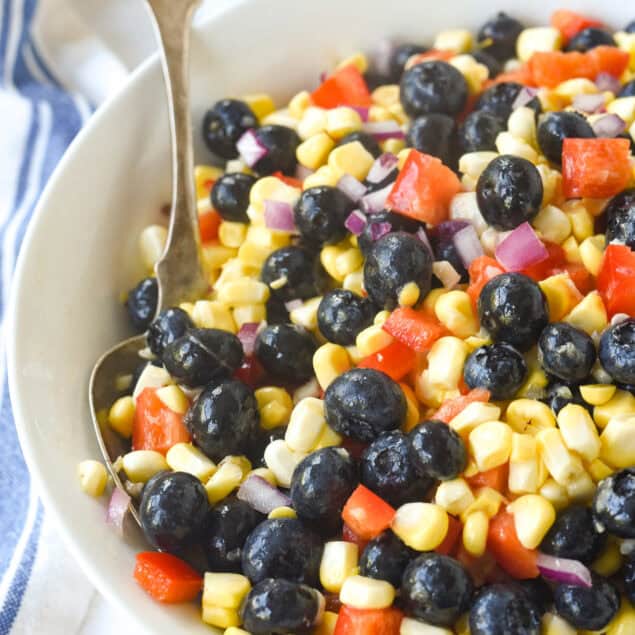 spoon in a bowl of blueberry corn salad