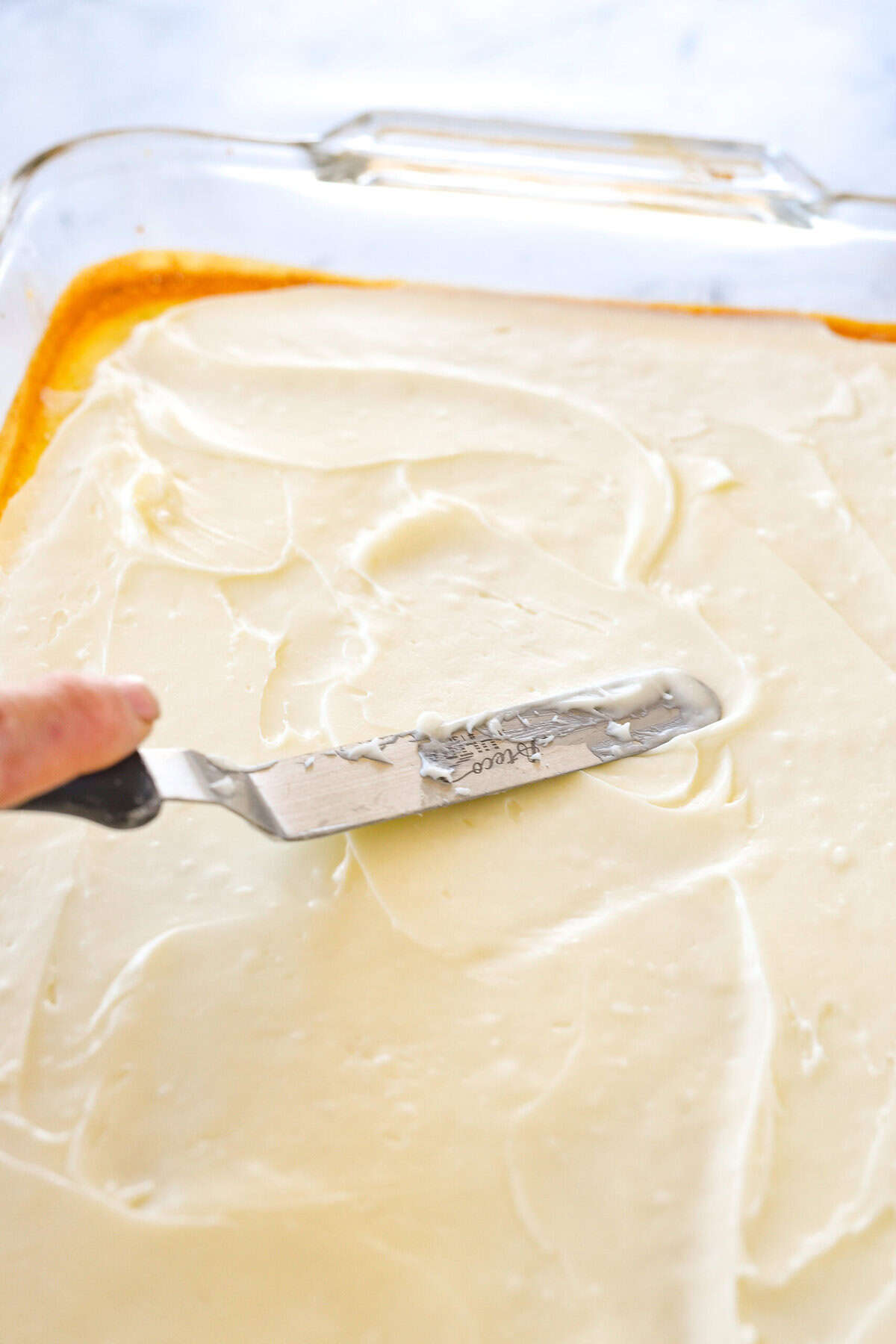 spreading frosting on key lime bars