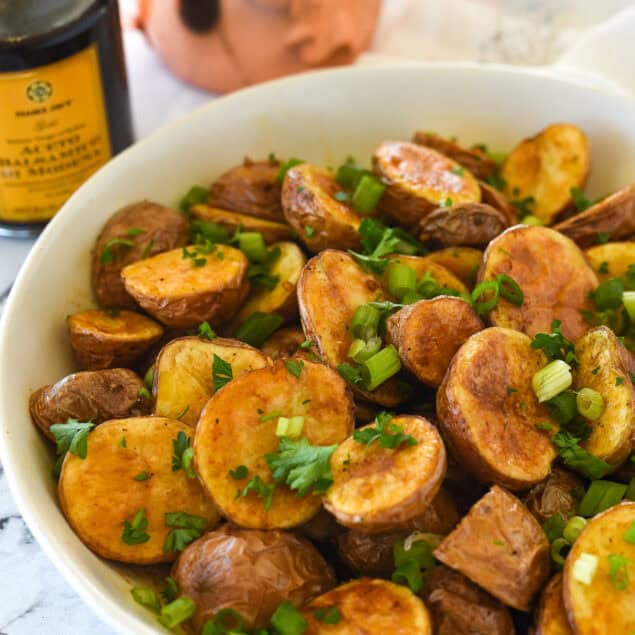 roasted balsamic potatoes iin a white bowl with parsley on top